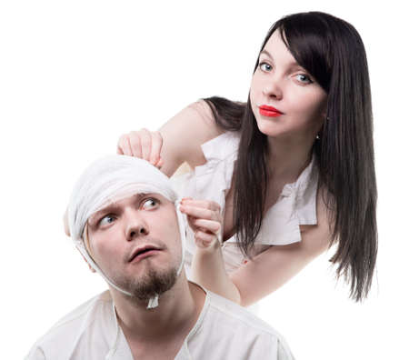 Sick man bandaged by nurseの写真素材