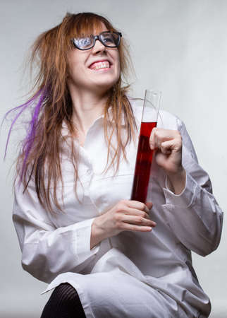 Scientist happy woman with red liquidの写真素材