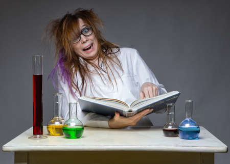 Reading laughing scientist with glass flaskの写真素材