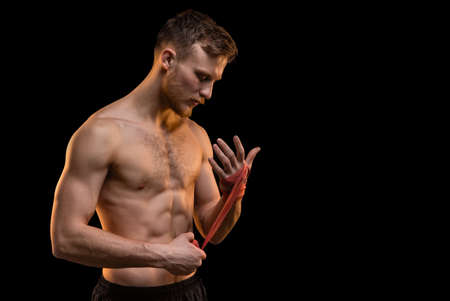 Bearded fighter man with boxing bandages on black backgroundの写真素材