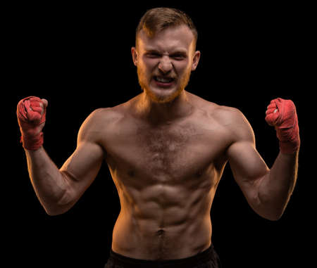 Muscular winner with hands upの写真素材