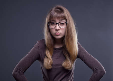 Skeptical young girl in glassesの写真素材