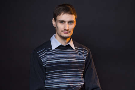 Serious brunette man wearing striped sweaterの写真素材