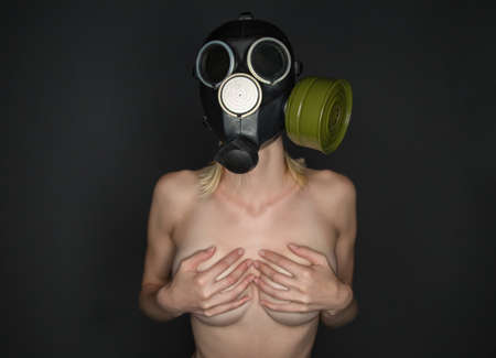 Slim woman in gas mask covered breastの写真素材