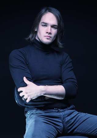 Puzzled brunette young man with arms crossedの写真素材