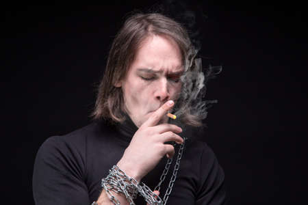 Smoking brunette man and chain