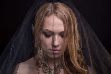 Depressive blond woman wearing black veilの写真素材