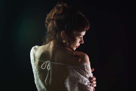 Girl undressing lace dress from backの写真素材