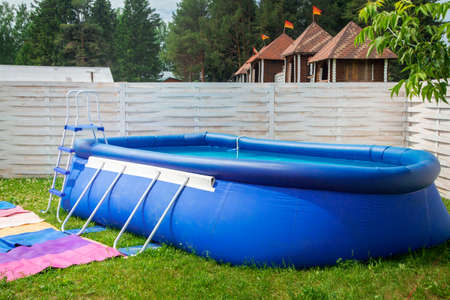 Blue inflatable pool among gardenの写真素材