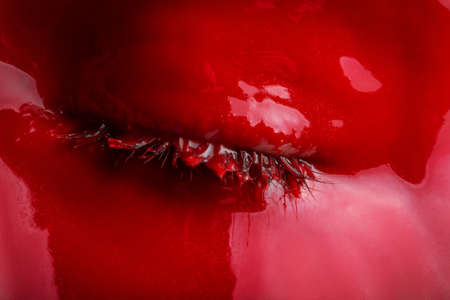Image of girls eye with red paint, close-up
