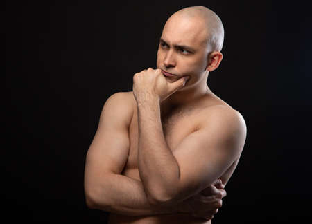 Photo of bald thoughtful man with bare shouldersの写真素材