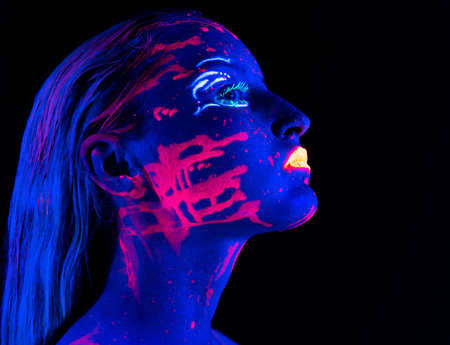 Photo of young woman with bright make-up in ultraviolet lightの写真素材
