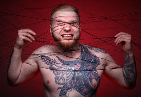 Photo of tangled in black threads bearded blond manの写真素材