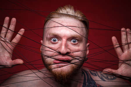 Photo of tangled in black threads scared manの写真素材