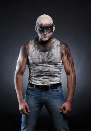 Portrait of bald aggressive dirty man on gray backgroundの写真素材