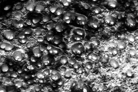 Black and white photo of perforated surface with little holesの写真素材