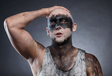 Portrait of bald dirty man with hand on headの写真素材