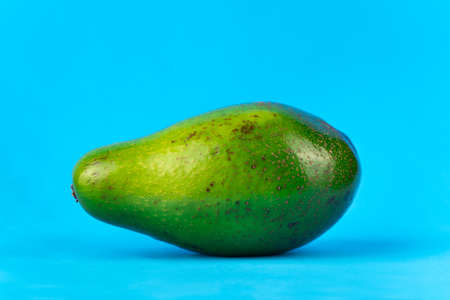 Image of ripe fresh green avocado on blue backgroundの写真素材