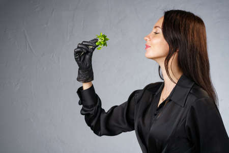 Photo of woman holding green sprouts in hand in profileの写真素材