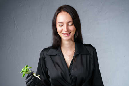 Photo of smiling woman holding green sprouts in handの写真素材