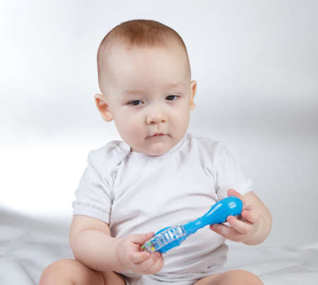 Photo of a ten-month-old baby boy with blue rattleの写真素材