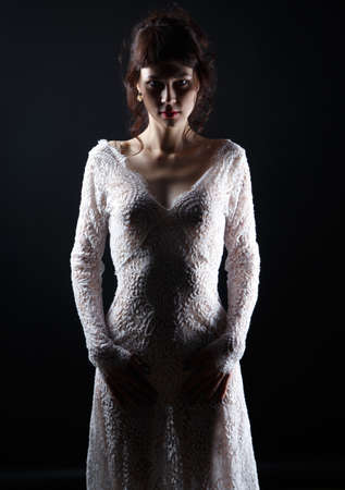 Image of young woman in see-through dress on dark backgroundの写真素材