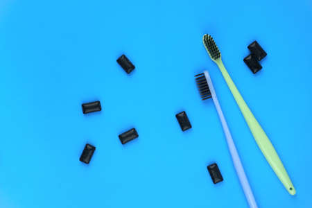 Image of black gum pads with toothbrushes on blue background