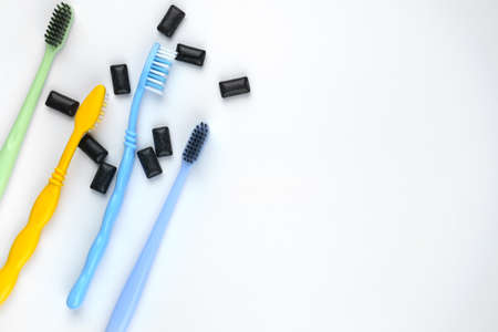 Photo of colorful toothbrushes on the left on isolated white backgroundの写真素材