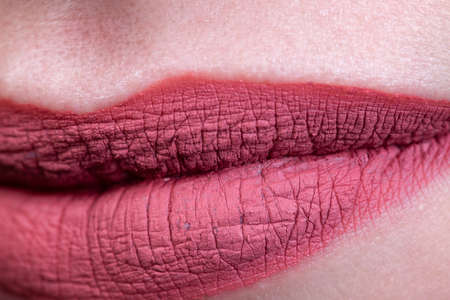 Close-up photo of womans lips with red matte lipstick