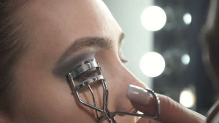 Shooting of master using eyelash curler on eyesの写真素材