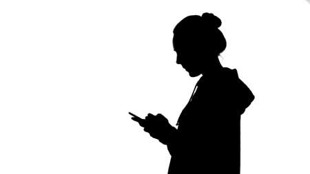 Girls silhouette with smartphone on white backgroundの写真素材