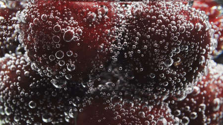 Photo of sweet cherry with bubbles of soda water