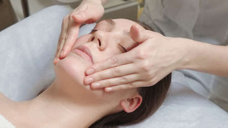 Photo of brunette woman gets a facial massage courseの写真素材