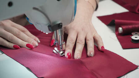 Shooting of tailor woman sewing clothes, close-up photoの写真素材