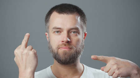 Photo of bearded man showing fuck gesture