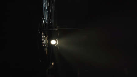 Photo of old film projector filming on black background