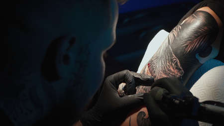 Close up photo of doing black tattoo of snake for woman in studio