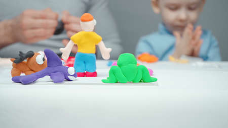 Dad and son sculpting animals from plasticineの写真素材
