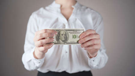 Shooting of businesswoman in white shirt with dollar in handsの写真素材