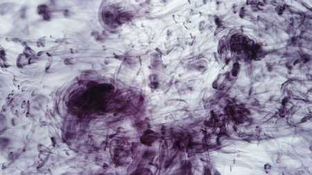 Image of drops of purple ink falling in water