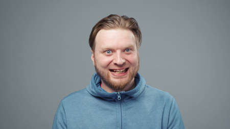 Photo of mad man in blue sweatshirt, closeup