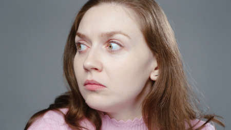 Photo of scared woman in pink turtleneck, portraitの写真素材