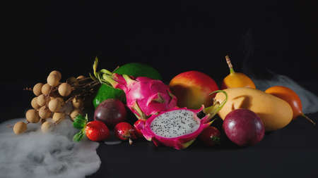Exotic fruits in the white smoke on black