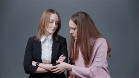 Photo of worried woman in pink jacket on gray backgroundの写真素材