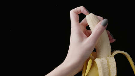 Shooting of the female hand breaking bananaの写真素材