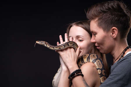 Image of two women with python on black backgroundの写真素材