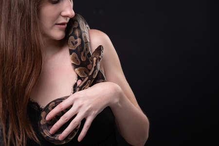 Photo of tender woman with snake on shoulderの写真素材