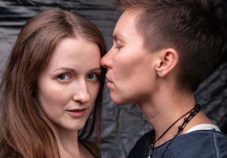 Photo of two kissing homosexual women on dark backgroundの写真素材