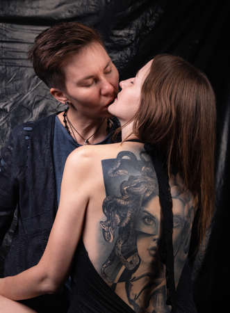 Two kissing homosexual women on dark backgroundの写真素材