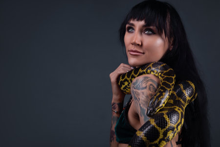 Photo of the woman with yellow anaconda on shoulders and neck
